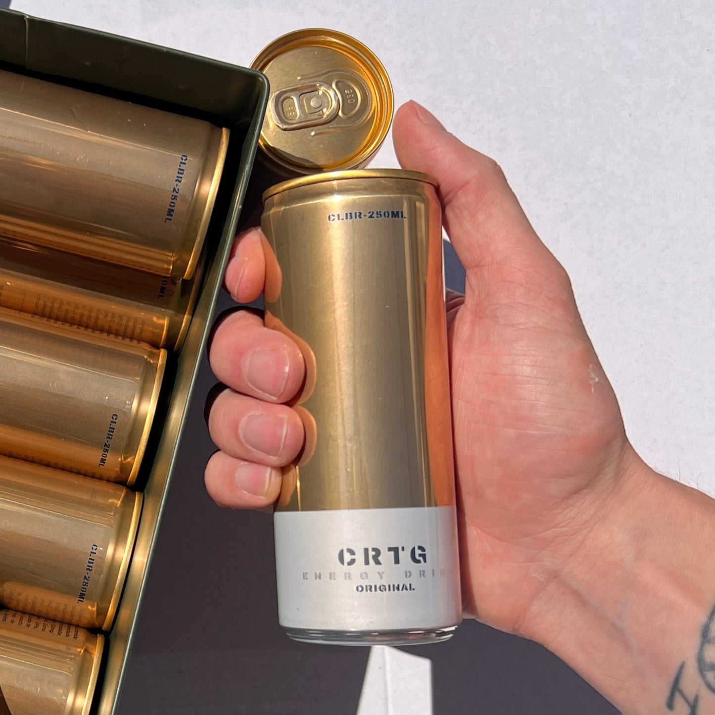 Mão a segurar lata de bebida energética com cafeína natural e zero açúcar, com sabor de Gengibre, limão e menta, venda online em Portugal