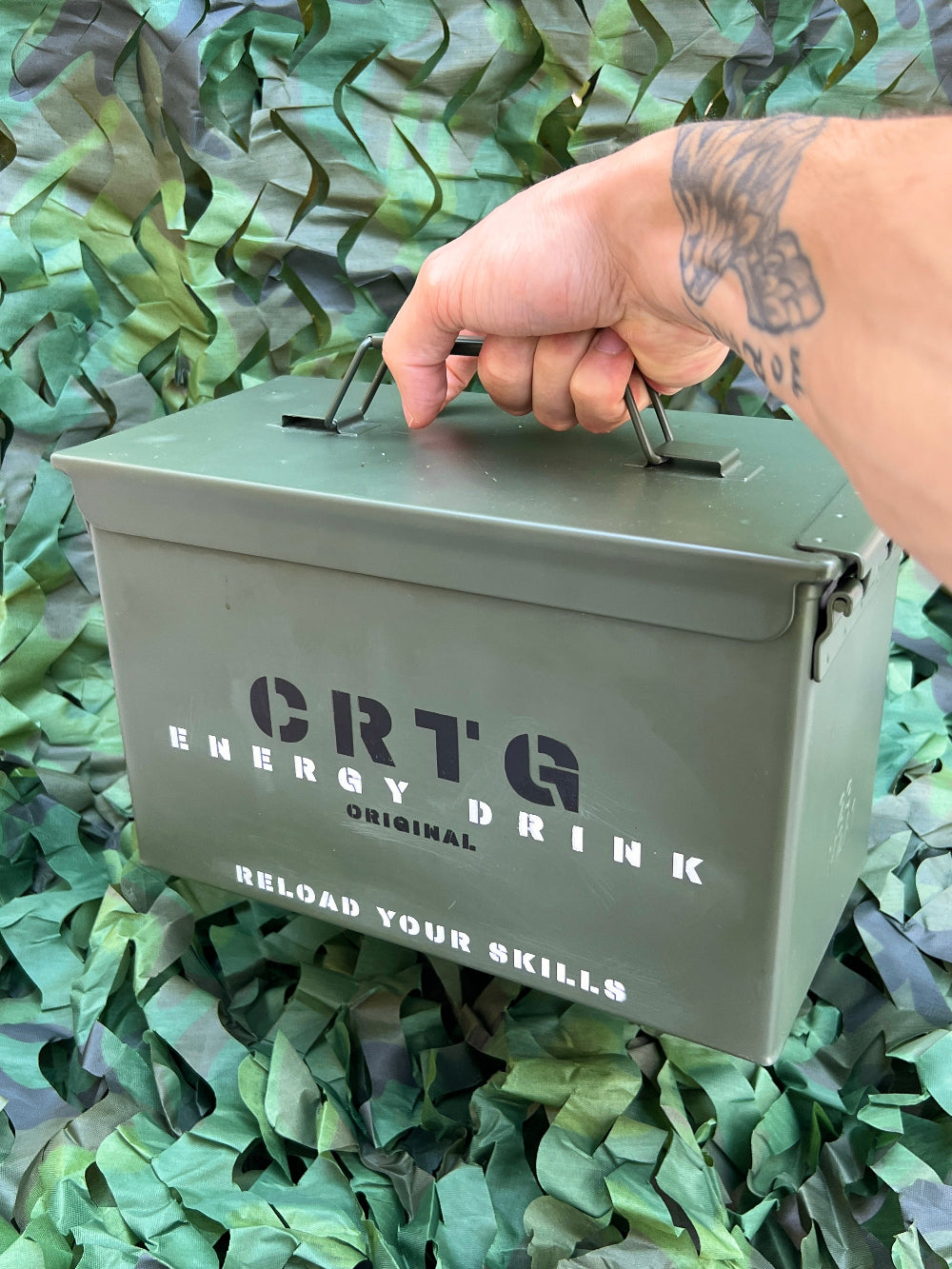 Caixa militar verde personalizada e com 12 latas de bebidas energéticas da CRTG